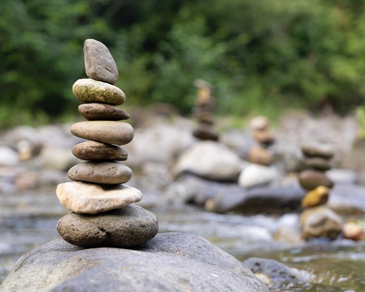A stack of smooth river stones beside the water