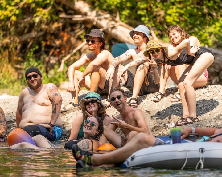 Friends relaxing on rocks beside the river