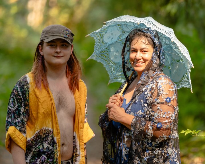 Two festival attendees standing together with a parasol