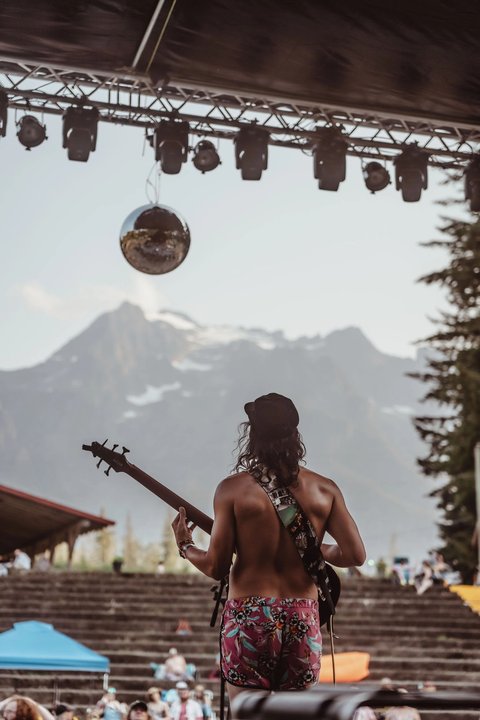 Performer on the main stage beneath a disco ball and mountain backdrop