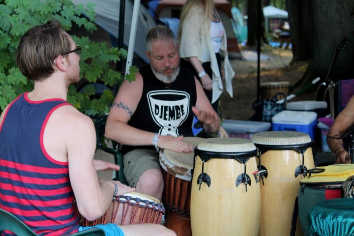 Festival attendees playing a circle of hand drums