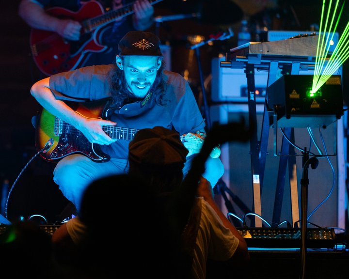 Guitarist performing under blue stage lighting