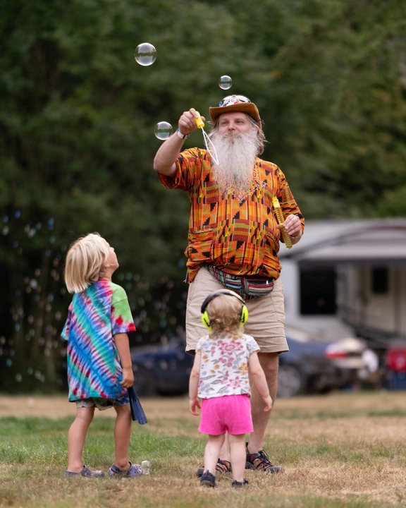 Adults and children enjoying bubbles outdoors