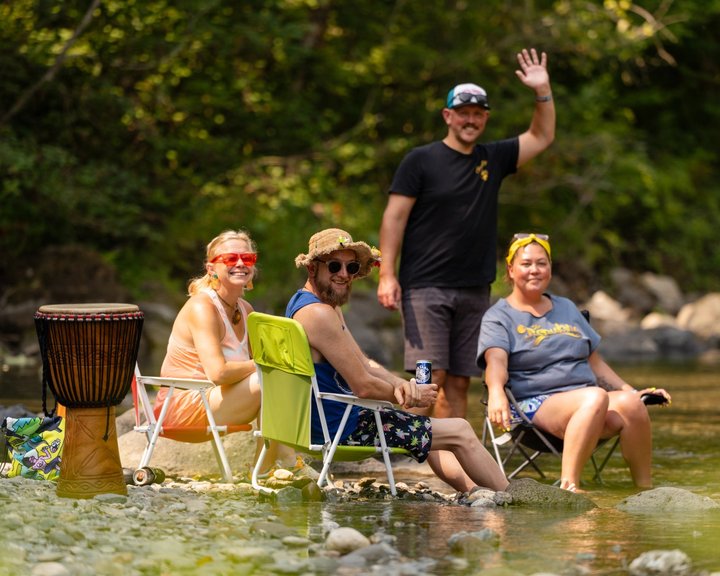 Friends relaxing in chairs beside the river