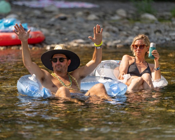 Festival attendees relaxing on floats in the river