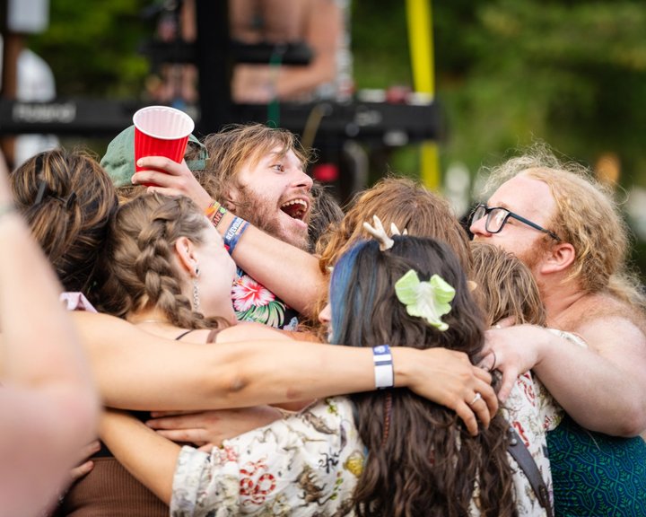 A group of festival attendees sharing a joyful hug
