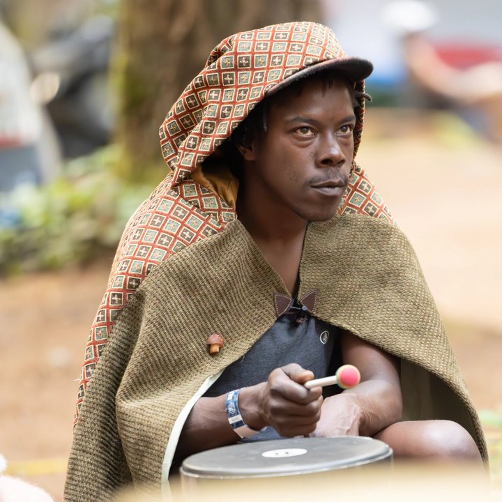 Festival attendee wearing a hooded blanket outdoors