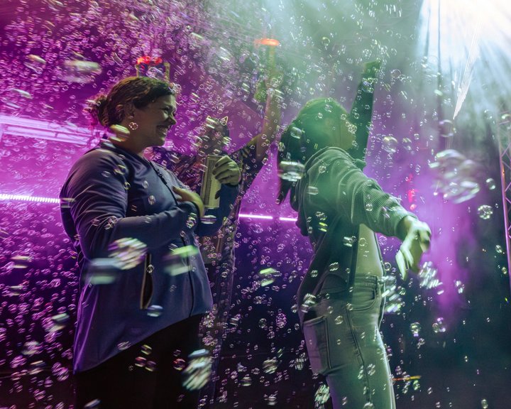 Musicians performing amid colorful stage lights